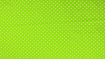 Green fabric with pink polka dots pattern for sewing and craft work © Top_Stock