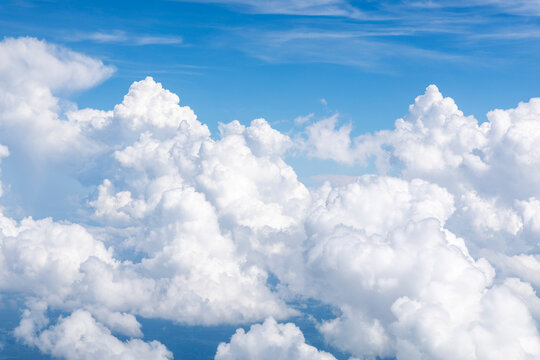 White, puffy clouds against a blue sky from an airplane
