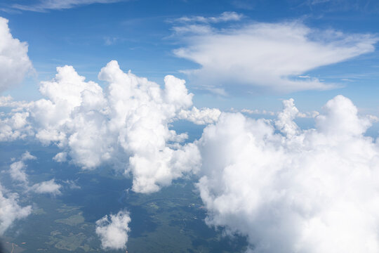 White, puffy clouds against a blue sky from an airplane