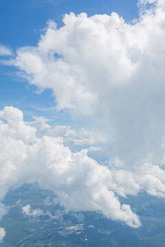 White, puffy clouds against a blue sky from an airplane