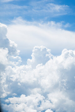 White, puffy clouds against a blue sky from an airplane