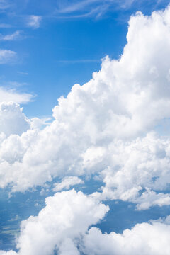 White, puffy clouds against a blue sky from an airplane