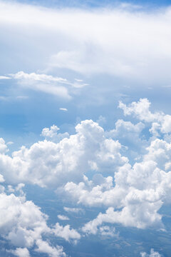 White, puffy clouds against a blue sky from an airplane
