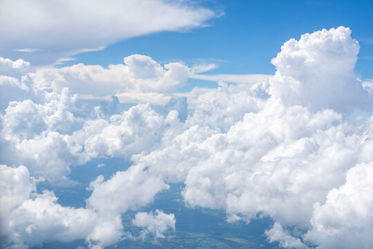 White, puffy clouds against a blue sky from an airplane
