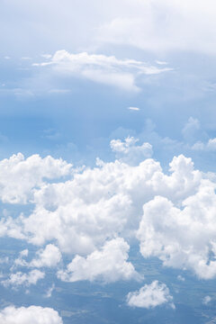 White, puffy clouds against a blue sky from an airplane