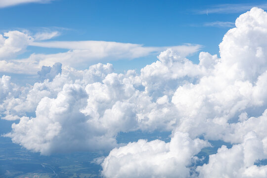 White, puffy clouds against a blue sky from an airplane