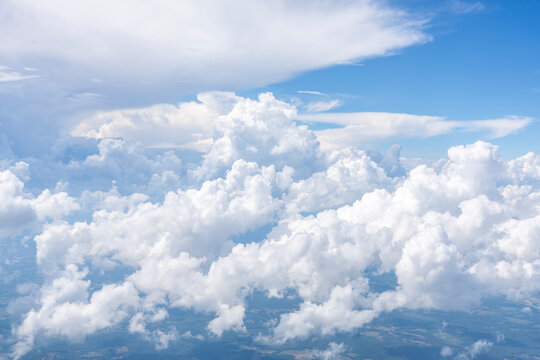 White, puffy clouds against a blue sky from an airplane