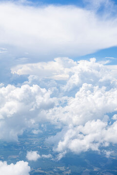 White, puffy clouds against a blue sky from an airplane