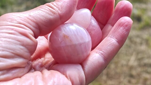 Natural rose quartz minerals in hand. Semi-precious multi-colored stones, minerals close-up. Mineralogy. Collection of minerals.