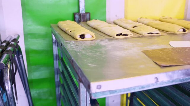 Unbaked sweet pastries preparing on a bakery metal tray