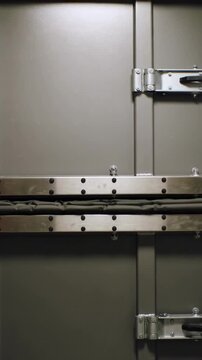 Vertical video: Closing metal hatch pressing pleated gasket and aligning steel strips, service area