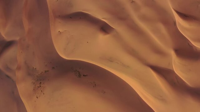 Aerial view of Gobi Desert sand dunes showing vast undulating golden sand formations under clear sky in MONGOLIA.