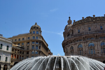 Piazza ferrari in Genoa city square with large fountain and historic ornate buildings under clear blue sky for travel background and architecture design © iri.madrid.art
