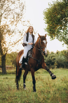 A woman jockey trains her horse to follow commands. The horse raises its leg at the command of the rider.