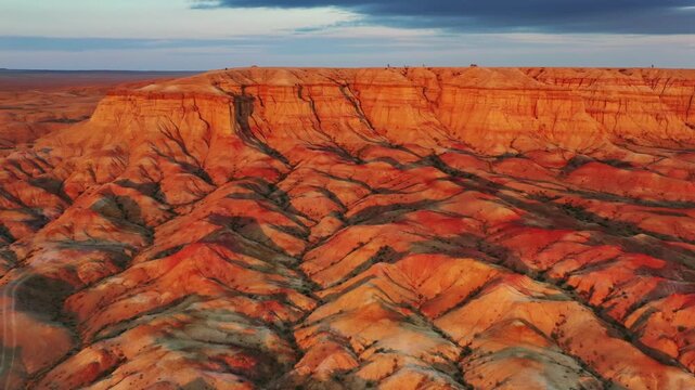 Aerial view of the colorful sedimentary rock formations of Tsagaan Suvarga, also known as the White Stupa, featuring vibrant orange and red layers in O'lziit, Dundgovi, Mongolia.
