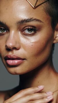 Vertical video: Responding to cue, model sliding hand up neck in studio, posing for ad with hairpin
