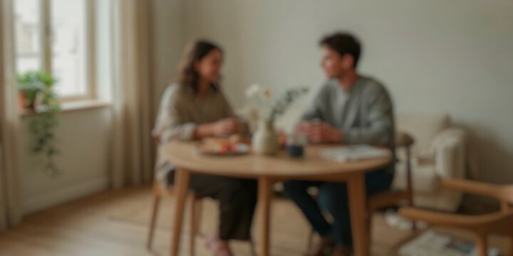 Blurred lifestyle scene of a couple talking over a meal at home, representing connection, wellness, communication, and everyday living.