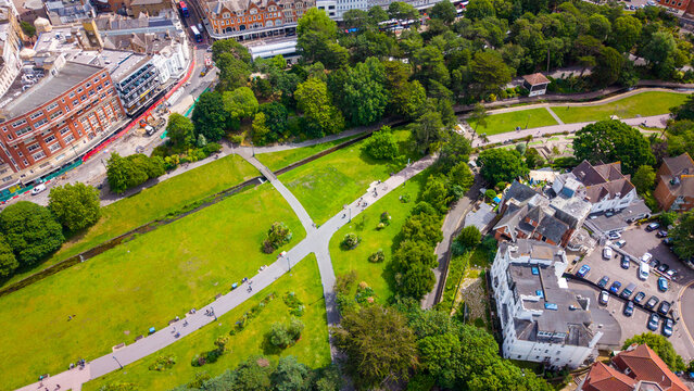 Aerial view of Bournemouth Lower Gardens with lush green lawns, winding footpaths, and surrounding urban architecture in Bournemouth, England, United Kingdom.