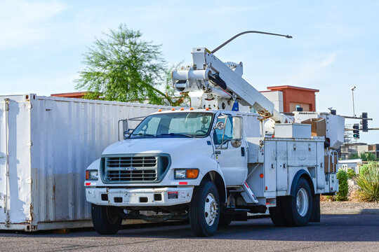 Streetlight maintenance truck with aerial lift parked at a work site, illustrating municipal lighting service, electrical infrastructure, utility maintenance, and public works operations
