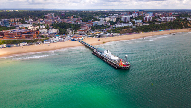 Aerial view of Bournemouth Pier extending into the sea, with sandy Bournemouth Beach, a ferris wheel, and the coastal town skyline in the background, Bournemouth, England, United Kingdom.