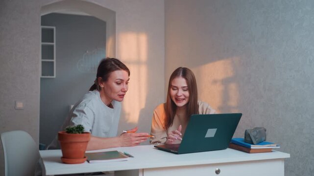 Home laptop tutoring white tutor guiding teen through grammar exercises in cozy study space, white adult coach explains sentence structure to attentive teenage student, warm sunset light