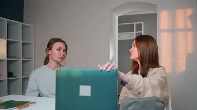 Caucasian mentor and student at desk tense grammar evaluation moment sunset light through window laptop closed notebooks arranged mentor observing student expression pause reflective mood constructive