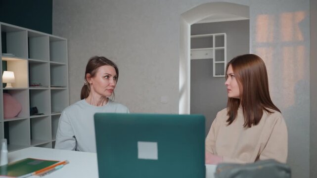 Caucasian tutor and student at desk calm grammar tutoring session with laptop open notebooks and pens on desk tutor explains sentence structure student practices exercises soft daylight from window