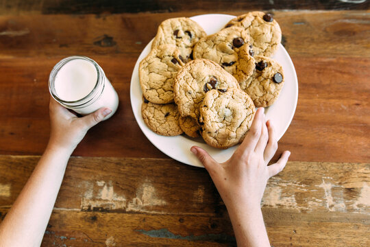 Child Reaching for Homemade Cookies and Milk