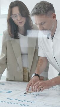 Professional team reviewing financial data, sharing success, collaborating around workplace documents, displaying corporate achievement and positive workplace dynamics. Business people concept