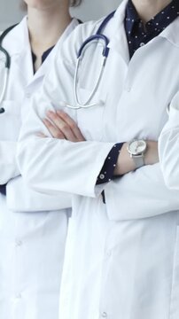 Doctors from a medical team are standing with arms crossed, wearing white coats and stethoscopes, representing unity, success, and trust in a healthcare environment