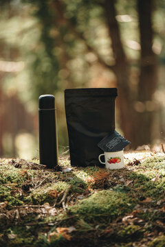 Camping coffee with drip bag, thermos and cup in forest