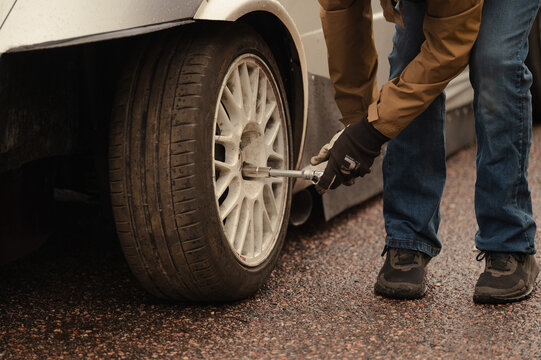 Mechanic change car wheel with impact wrench at racetrack