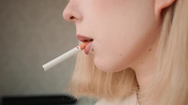 Adolescent pauses before lighting up cigarette. Teenager hesitates briefly as peer gets ready to smoke. Young individual pauses momentarily before taking puff from cigarette with piercing