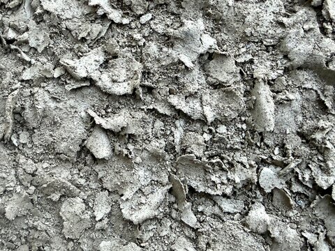 Extreme close-up shot of dry, cracked, and flaking mud or clay soil.