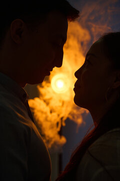 Silhouette couple gaze at sunset with warm romantic glow