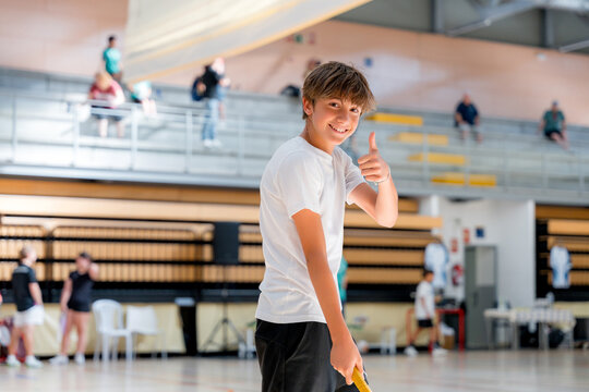 Junior badminton player show thumb up at tournament