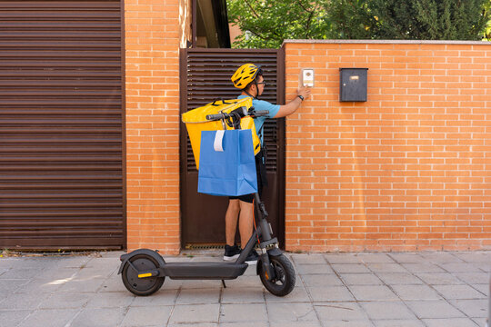 Scooter courier deliver order at residential doorbell