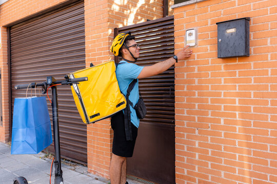 Scooter courier deliver order at apartment building entrance