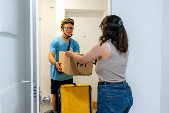 Scooter courier deliver parcel to customer at apartment door