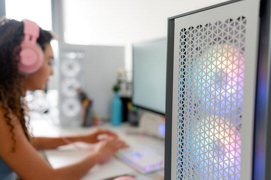 Young woman gaming on desktop computer with headset