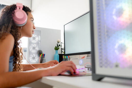 Young woman play computer game at desktop workstation