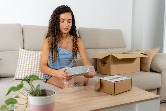 Young woman packing sold item for second-hand marketplace