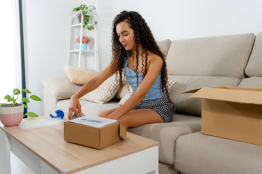 Young woman pack sold item for online marketplace shipment