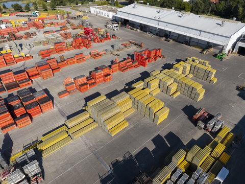 Aerial view of the PERI Polska Sp. z o.o. facility featuring organized stacks of orange and yellow construction formwork in a paved yard in Jaworzno, Wojewodztwo slaskie, Poland.