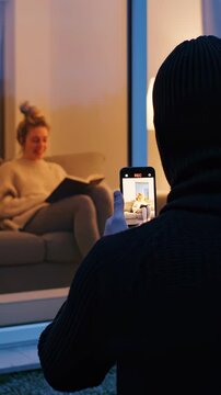 Stalker Secretly Filming Unsuspecting Woman Through Window at Home STALKING AND PURSUIT CONCEPT