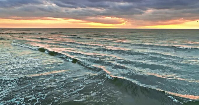 Calm waves at Baltic sea by sunset in Poland.