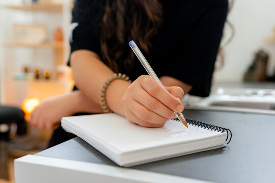 Female therapist writing clinical notes during consultation