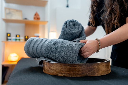 Therapist preparing towel for massage treatment at wellness clinic