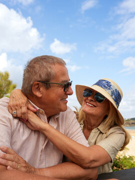 Senior couple embrace on beach during summer vacation