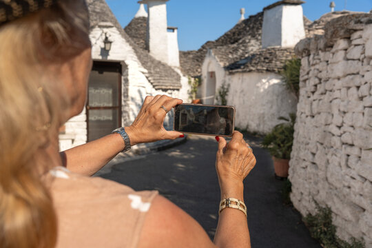 Tourist photograph trulli houses in Alberobello, Puglia
